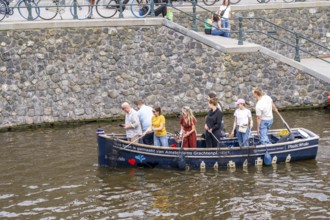 Plastic Whale boat in a canal in Amsterdam, passengers fish plastic waste out of the canals, tour