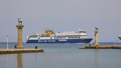 Ferry boat sailing between columns with statues on blue sea, Deer statue, Deer statue, Mandraki