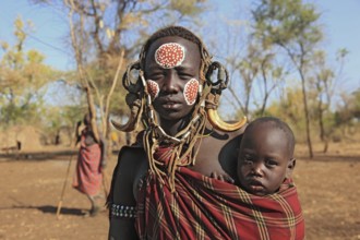 South Ethiopia, in Maco National Park, Mursi tribe, Mursi woman with baby, painted skin and