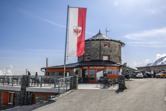 In front flag flag of South Tyrol behind it historic mountain hotel hotel restaurant bar inn alpine