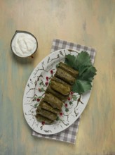 Dolma, cabbage rolls in grape leaves, Traditional Armenian dish, with white sauce, top view,