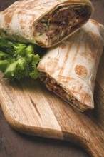 Cut shawarma, 2 pieces, on a cutting board, close-up