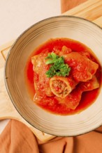 Stuffed cabbage rolls, with minced meat, in tomato sauce, on a beige background, food and drink,