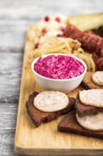 Set of snacks: sausages, toast, sauerkraut, marinated onion and cucumber, baked potato on a cutting