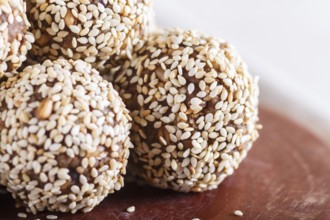 Energy balls cakes with almonds, sesame, cashew, walnuts, dates and germinated wheat on wooden