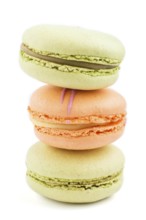 Orange and green macarons or macaroons cakes isolated on white background. side view, close up,