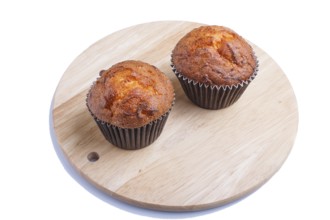 Two carrot muffins on wooden kitchen board isolated on white background. closeup