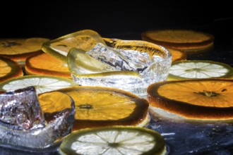 Transparent slices of fresh oranges and lemons on the glass with ice