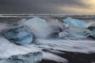 Ice floes on the beach, waves, sea, clouds, sunlight, winter, Diamond Beach, Breidamerkursandur,