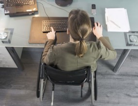 Young woman in a wheelchair at her workplace, Berlin, 18/01/2017