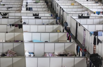 Temporary rooms with beds are set up in an emergency shelter for refugees on 9 December 2015 in a