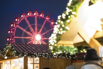 Ferris wheel behind a stand at the Christmas market on Alexanderplatz, Berlin, 21.12.2024