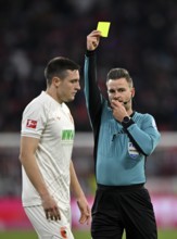 Referee Referee Daniel Schlager shows Keven Schlotterbeck FC Augsburg FCA (31) yellow card yellow