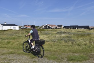 Woman, senior citizen cycling through Jutland in Denmark