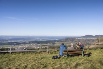 Hikers resting on a bench at the viewpoint from the 980 metre high Klippeneck on the western edge