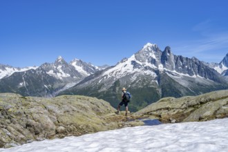 Mountaineer on a hiking trail in front of a mountain landscape, view of mountain peak Aiguille