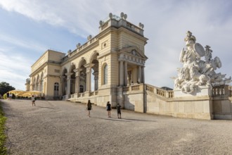 Monumental building with sculptures and columns, in an open area under a blue sky, Vienna