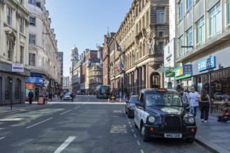 View of a busy city street with taxis and historic buildings, Liverpool