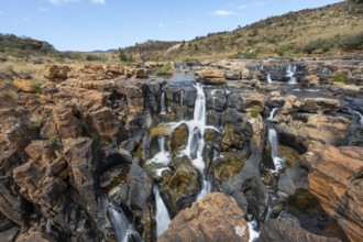 Waterfalls between orange-coloured rocks on the Treur River, Bourke's Luck Potholes, long exposure,