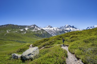 Mountaineer on hiking trail near the Col des Posettes, mountain panorama with glaciated peaks,