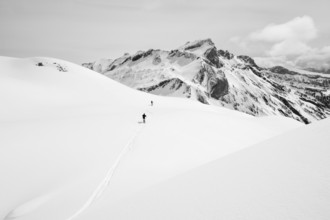 Two lonely ski tourers in a snowy mountain landscape, mountain peak Sex des Molettes in the