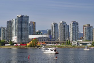 Cityscape with modern buildings and boats along the waterfront on a summer day, False Creek,