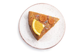 Piece of orange cake on ceramic plate isolated on a white background. Top view, close up