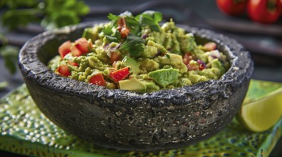 Traditional Mexican healthy cuisine, avocado guacamole served on molcajete. Healthy diet concept,