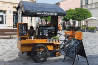 Mobile coffee stand on a bicycle, placed in a busy pedestrian zone in the sunshine, Lublin, Poland,