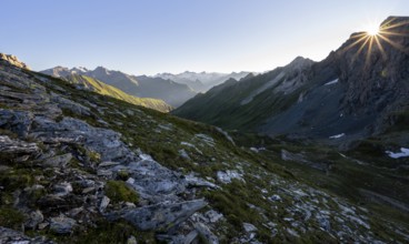 Mountain landscape at sunrise with sun star, view of mountain peaks of the Venediger group and into