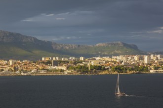 Sailboat on Adriatic sea heading towards the Dalmatian coast of Split at sunset in late summer,