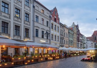 The lights come on in the evening in the restaurants on Chelminska Street in the historic centre of