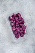 Freshly frozen beetroot khinkali, in a container, top view, no people