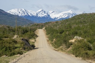 Road Carretera Austral north of Cochrane, gravel road in front of snowcovered mountains, Patagonia,