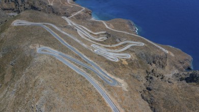 Aerial view of pass road serpentines from to Passo Anopoli above south coast of Crete right Libyan