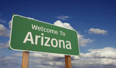 Welcome to arizona green road sign over blue sky with some clouds