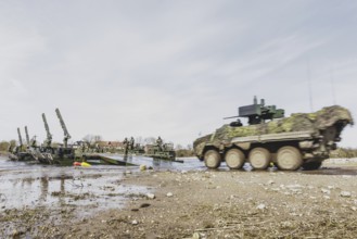 A Pandur II tank navigates the Bundeswehr's Amphibie M3 floating high-speed bridge in the Elbe as