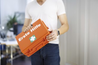 Occupational safety. A man holds a first aid kit in an office in Berlin, 09/08/2024