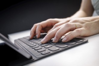 Hands typing on a tablet with keyboard in Berlin, 09/08/2024