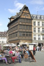 Street pub with people and Maison Kammerzell built in 1427, historic half-timbered house,