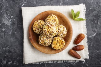 Energy ball cakes with dried apricots, sesame, linen, walnuts and dates with green mint leaves in a