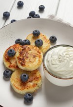 Cottage cheese pancakes, with blueberries, breakfast, on a white wooden table, no people, top view