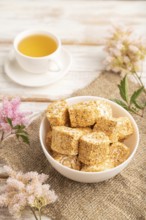 Traditional turkish delight (rahat lokum) in white ceramic plate with cup of green tea on a white