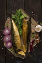 Smoked mackerel, top view, with spices, on a wooden table, no people, selective focus