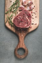 Fresh, raw rib eye steak, on a chopping board, top view, no people