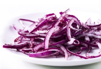 Sliced into half rings, red onion, with Sumac spice, on a white background, no people