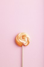 Single lollipop candy on pink pastel background. copy space, top view, flat lay