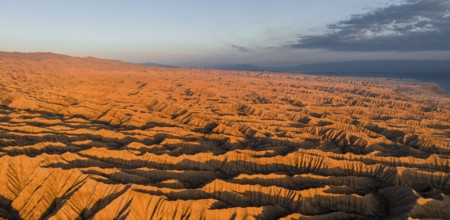 Landscape of eroded hills at Lake Issyk Kul, Badlands at sunrise, aerial view, Canyon of the