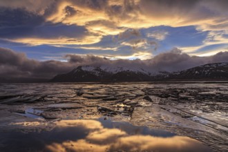 Cloudy mood and evening light over a fjord, ice floes, mountains, winter, windy, Lonsvik, East