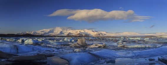 Ice floes in lake in front of glacier and mountains, panorama, morning light, Jökulsarlon,